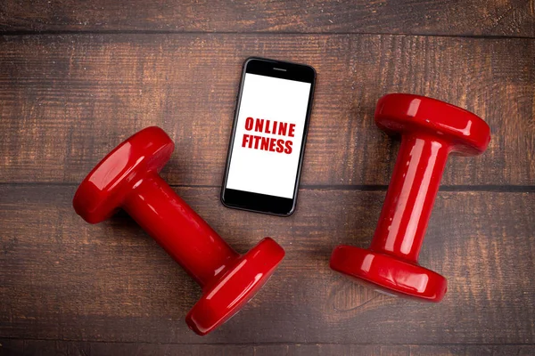 depositphotos 366604744 stock photo red dumbbell smartphone woodan background